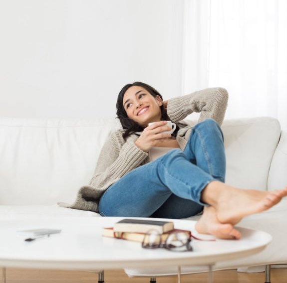 Frau entspannt auf dem Sofa