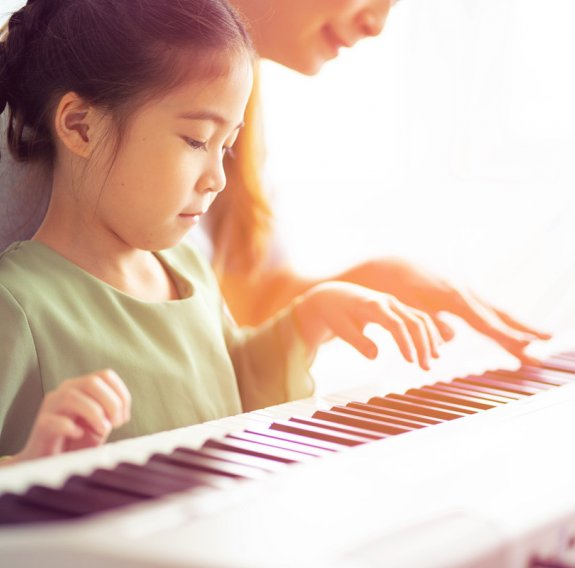 Kind erlernt Keyboard spielen