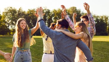 Eine Gruppe von jungen Erwachsenen geben sich gegenseitig ein High 5
