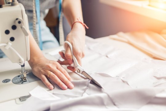 Nähmaschine und Stoffe liegen auf dem Tisch