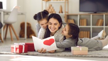 Eine Mutter mit ihren zwei Kindern sitzt auf dem Boden