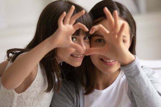 Mutter und Tochter machen aus Händen ein Herz