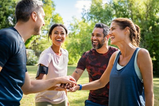 Gruppe von jungen Menschen stehen in einem Teamkreis zusammen