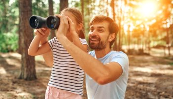 Kind und Vater entdecken Natur im Wald