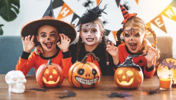 Drei glückliche Kinder in Halloween Kostümen