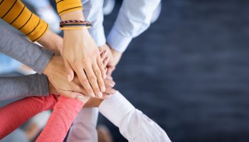 mehrere Hände halten alle aufeinander