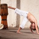 Kleiner Junge macht Capoeira.