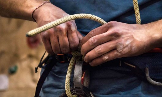 Mann legt Kletterequipment an