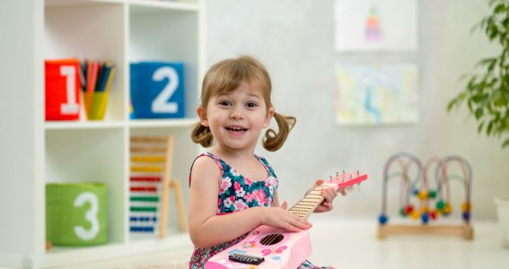 Mädchen hält eine kleine Gitarre