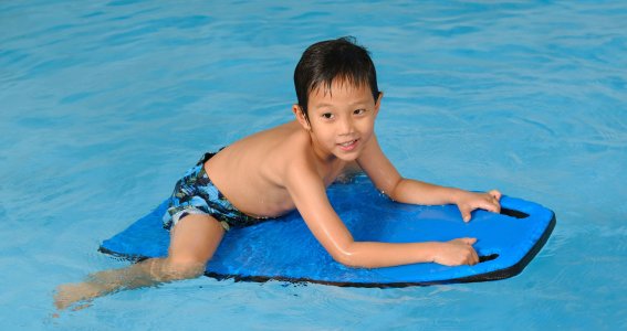 Junge auf Schwimmbrett