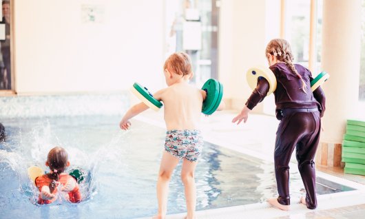 Mädchen und Junge springen ins Wasser bei Aquabell