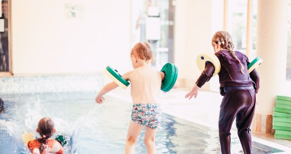 Mädchen und Junge springen ins Wasser bei Aquabell