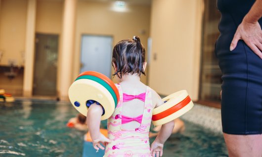 Mädchen springt im Schwimmkurs ins Wasser