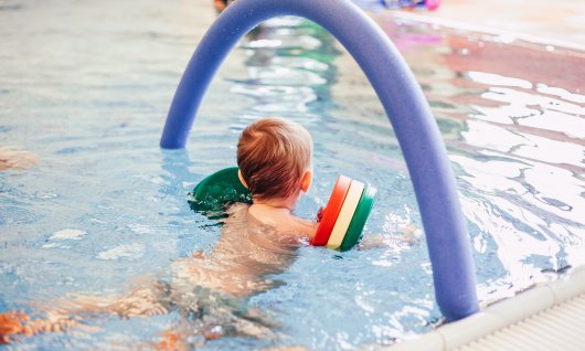 Junge im Schwimmkurs mit Schwimmflügeln in München Junge im Schwimmkurs mit Schwimmflügeln in München