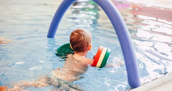 Junge im Schwimmkurs mit Schwimmflügeln in München