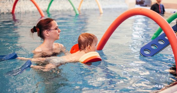 Mutter und Sohn schwimmen durch einen Tunnel bei Aquabell in München