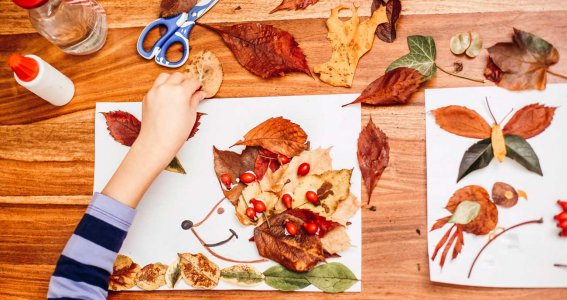 Kinder basteln mit verschiedenen Blättern.