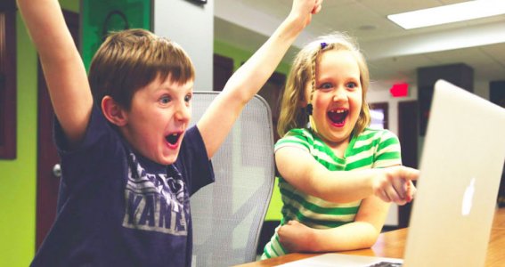 Zwei Kinder freuen sich vor dem Laptop