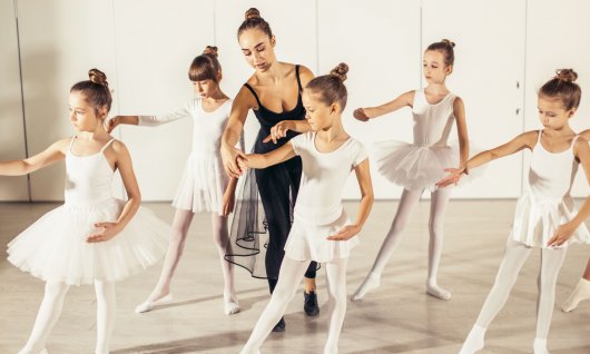 Mädchen üben Balletthaltungen in der Gruppe. 