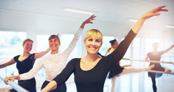 Frauen üben Ballett zusammen in einem Raum. 