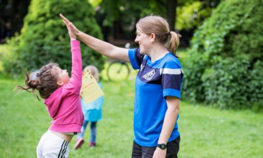 Kleines Mädchen macht High Five mit erwachsener Frau