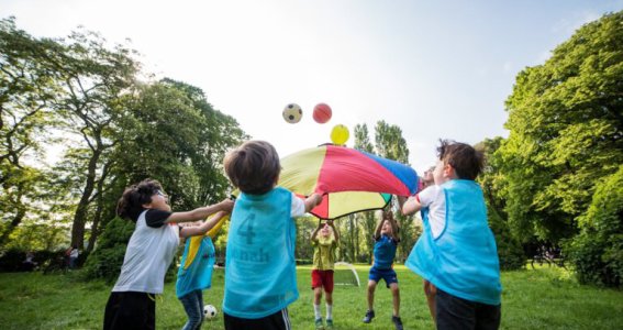 Kinder halten ein buntes Netz mit Bällen in der Hand