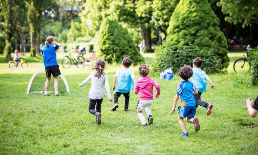 Kinder laufen in Richtung Fußballtor