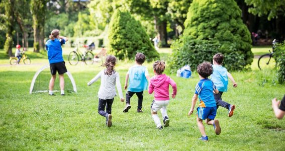 Kinder laufen in Richtung Fußballtor