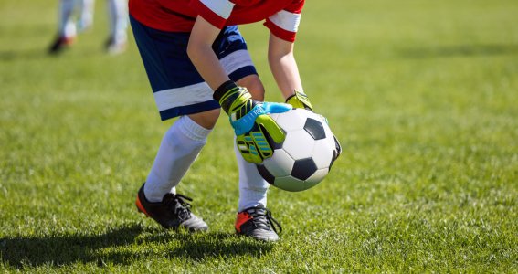 Ein Junge legt einen Fußball auf das Fußballfeld