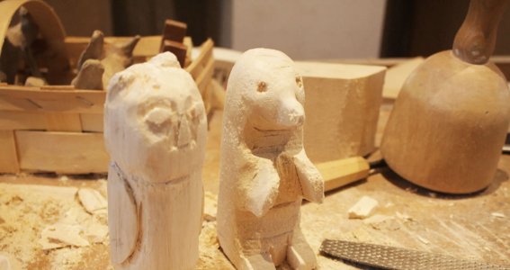 Zwei Tierfiguren aus Holz geschnitzt stehen auf dem Tisch
