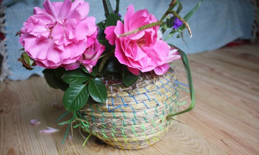 Selbstgeflochtener Korb mit rosa Blumen