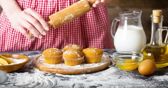 Eine Frau backt Muffins mit verschiedenen Zutaten