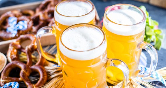 Ansicht von oben auf drei Gläser Bier verziert mit Brezeln und anderer Tischdekoration