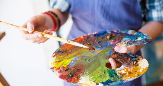 Ein Künstler hält eine Farbpalette und einen Pinsel