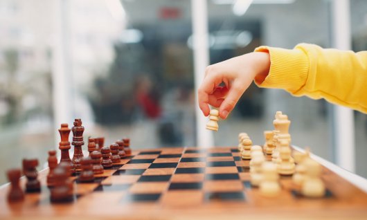 Schachbrett und Kind macht den ersten Zug