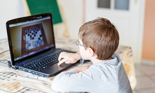Kleiner Junge spielt online Schach
