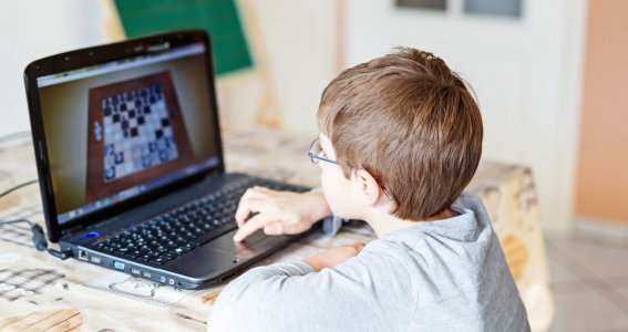 Kleiner Junge spielt online Schach