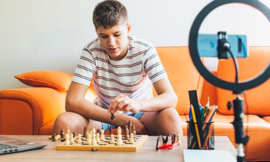 Junge im Teenageralter spielt auf dem Sofa Schach