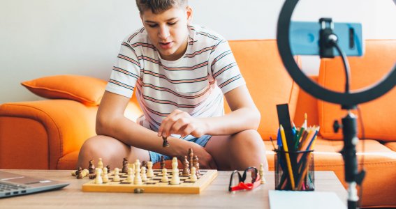 Junge im Teenageralter spielt auf dem Sofa Schach