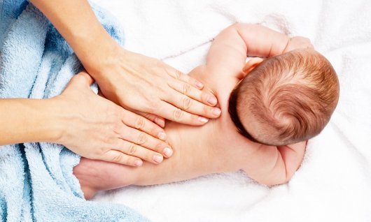 Online Babymassage für Eltern Baby was am Rücken massiert wird.
