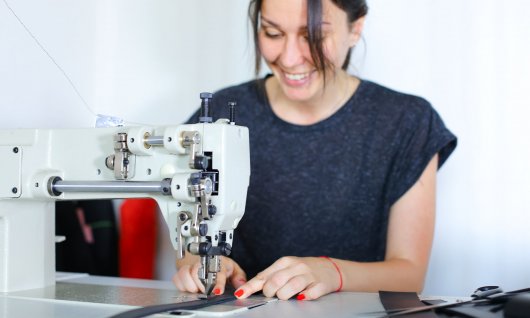 Frau näht  an einer Nähmaschine. 