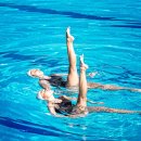 Zwei Mädchen schwimmen synchron im Wasser