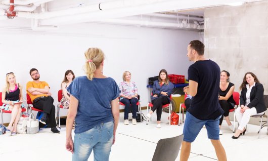 Schauspieler sitzen im Kreis und lernen dazu.