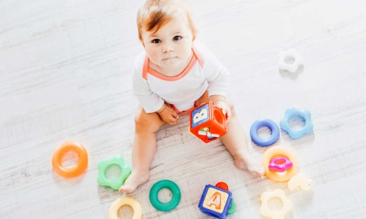 Ein Baby spielt mit verschiedenen Spielzeugen 