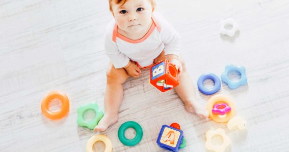 Ein Baby spielt mit verschiedenen Spielzeugen 