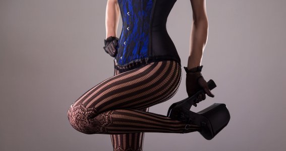 Ein Frauenkörper in blauem Korsett und schwarzen High Heels