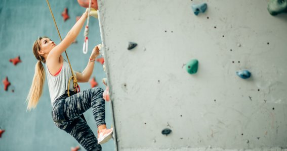 Frau klettert in Kletterhalle