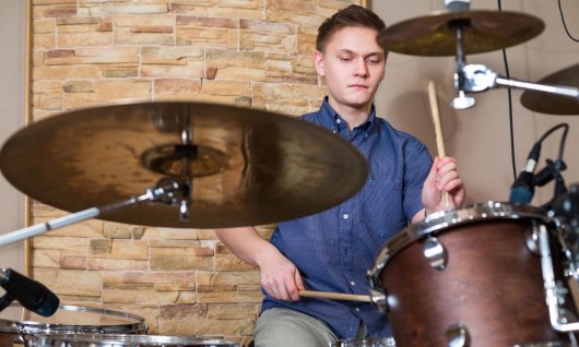 Junge sitzt am Schlagzeug