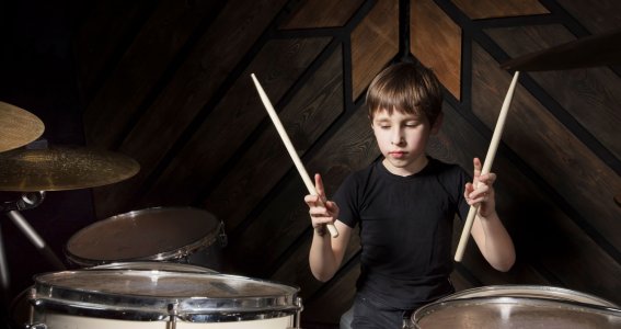 Junge sitzt am Schlagzeug