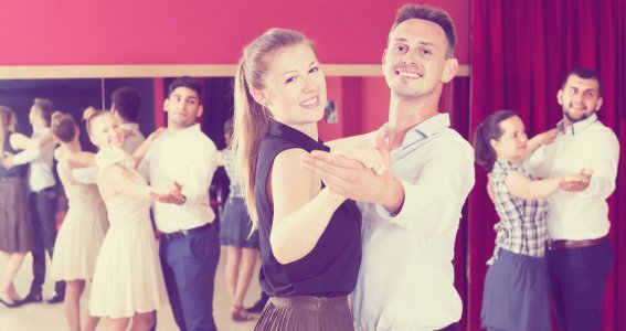 Pärchen tanzen zusammen in einer Tanzschule.